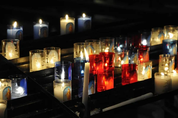 stock image Close-up on lot of religious candles on a black support in a church