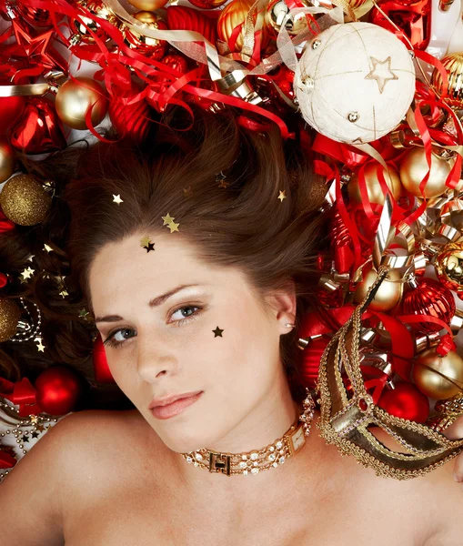 Bella bruna sdraiata tra le decorazioni natalizie Immagini Stock Royalty Free