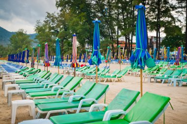 Empty chaise lounges on a beach clipart