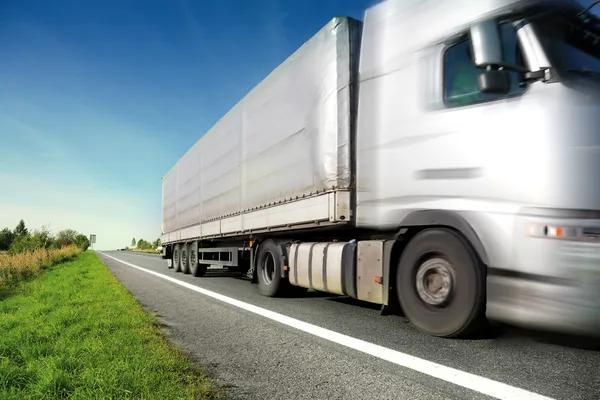 Zilveren vrachtwagen rijden op landweg — Stockfoto