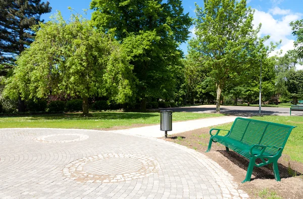 緑豊かな公園のベンチ — ストック写真
