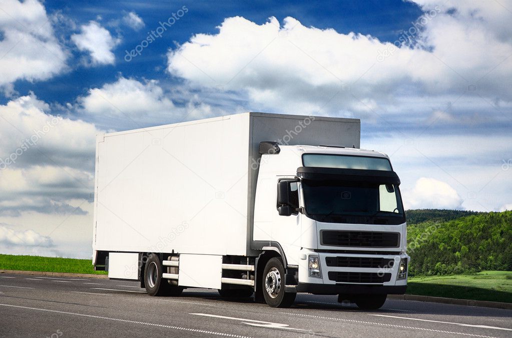 White truck driving on a road