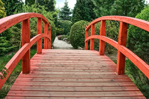 Деревянный мост в зеленом саду — стоковое фото