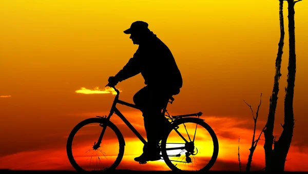 骑自行车的人日落时的剪影 — 图库照片