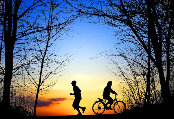 Rekreation, jogging och cykling i solnedgången — Stockfoto