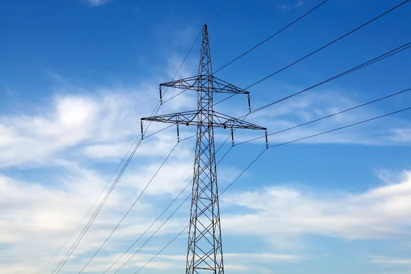 Pilone elettrico e linee elettriche su cielo blu — Foto Stock