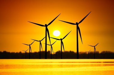 Wind turbines over sunset clipart