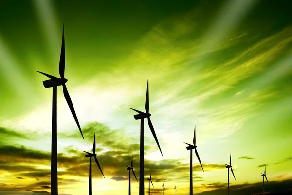 Fazenda de turbinas eólicas ao pôr do sol Fotografias De Stock Royalty-Free