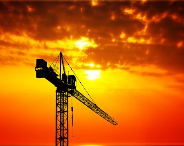 Industrial construction crane at sunset clipart