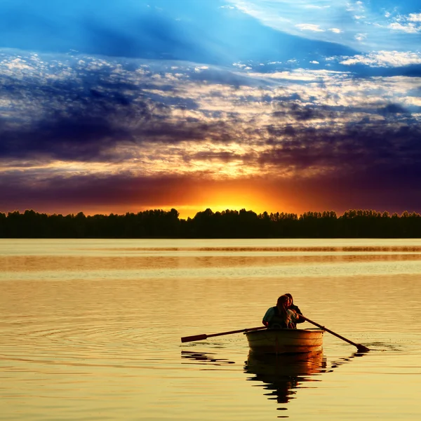 Par i båten mot en vacker solnedgång — Stockfoto