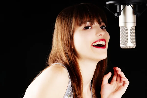 Girl singing to the microphone in a studio — Stock Photo, Image