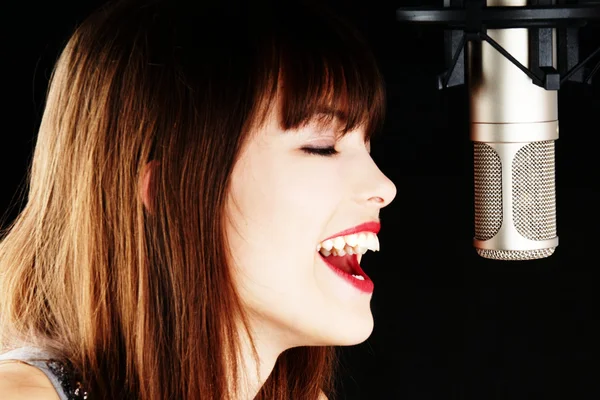 Chica cantando al micrófono en un estudio —  Fotos de Stock