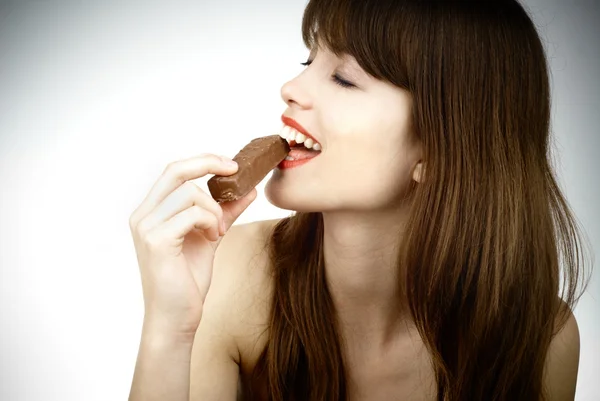 Femme sexy manger une barre de chocolat - plan studio — Photo