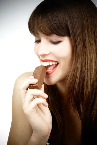 섹시 한 여자 먹는 초콜릿-스튜디오 촬영의 바 스톡 이미지