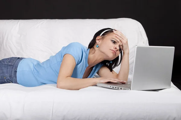 Csinos, fiatal nő ült az ágyra vele laptop — Stock Fotó