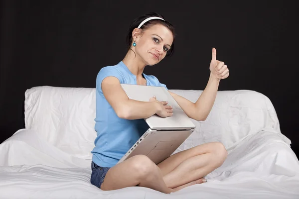 예쁜 젊은 여 자가 그녀의 노트북으로 침대에 앉아 — 스톡 사진