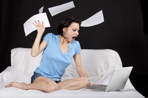 Pretty young woman sitting on bed with her laptop — Stock Photo, Image