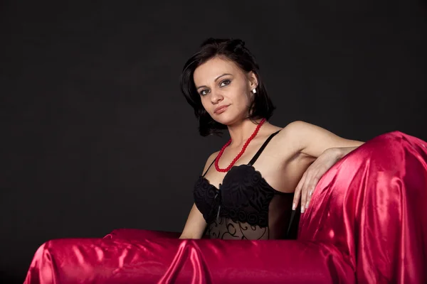 Sexig kvinna i svart underkläder på satin säng — Stockfoto