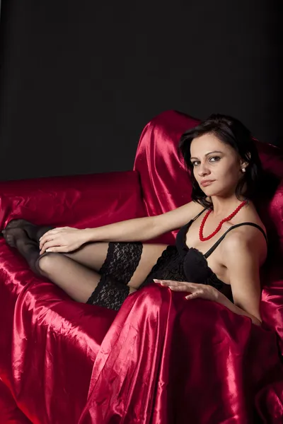 Donna sexy in lingerie nera sul letto di raso — Foto Stock