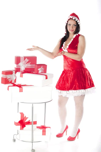 Una hermosa chica morena vestida de ayudante de Santa Claus con regalos — Foto de Stock