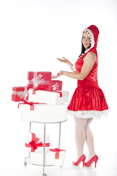 Uma linda menina morena vestida de Papai Noel; s ajudante com presentes — Fotografia de Stock