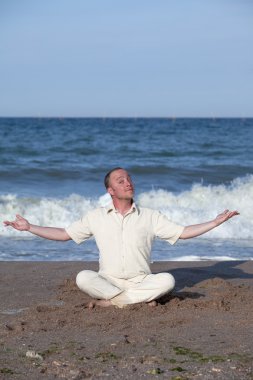 genç işadamı bir plajda yoga yaparken