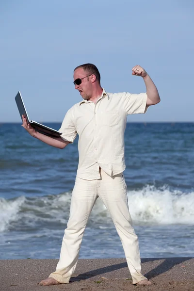 彼のラップトップをパンチ ビーチで日焼けした実業家 — ストック写真
