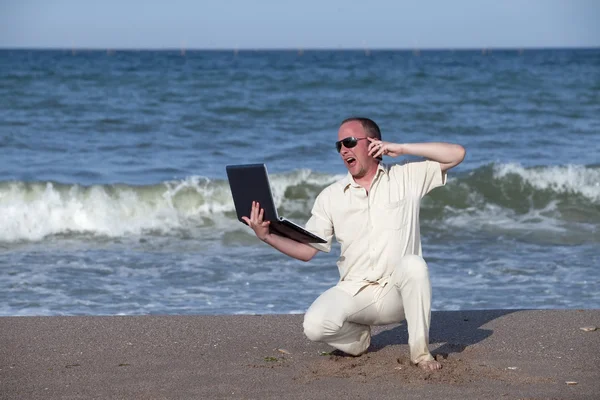 Sonnengebrannter Mann mit Handy und Laptop — Stockfoto