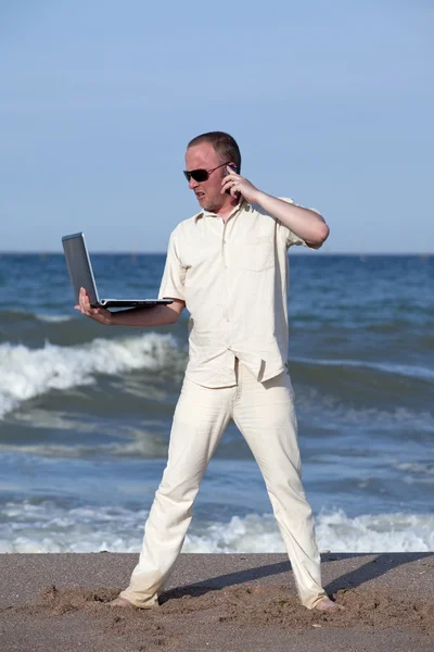 Arg man stans laptop på stranden — Stockfoto