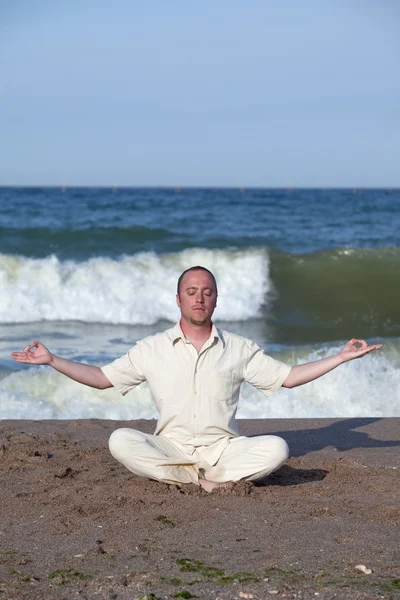 Giovane uomo d'affari che fa yoga su una spiaggia — Foto Stock