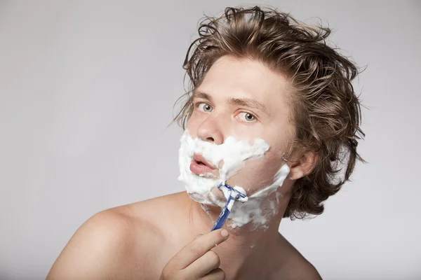 Attractive young man shaving — Stock Photo, Image