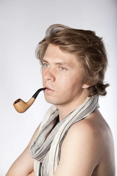 Atraktivní mladý muž kouření potrubí — Stock fotografie