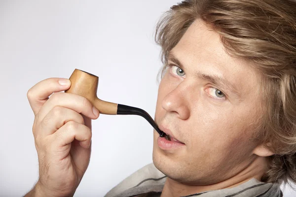 Attractive young man smoking pipe — Stock Photo, Image