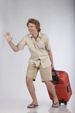 Young handsome male model with trolley running and waving clipart