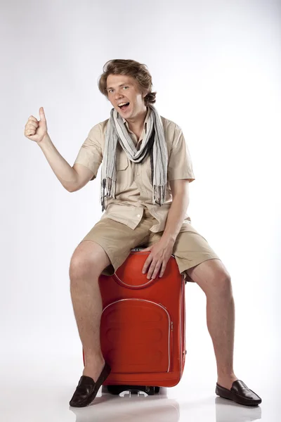 若い観光ヒッチハイク彼の荷物の上に座っての終了 — ストック写真