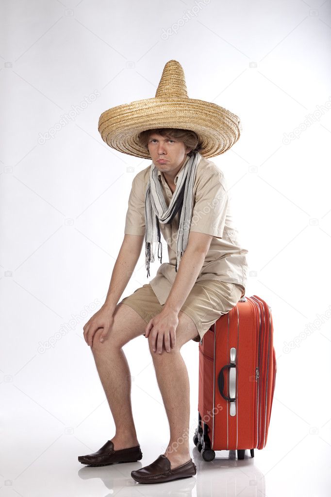 Sad young mexican man sitting on his luggage being disappointed or confused. See more in my portfolio