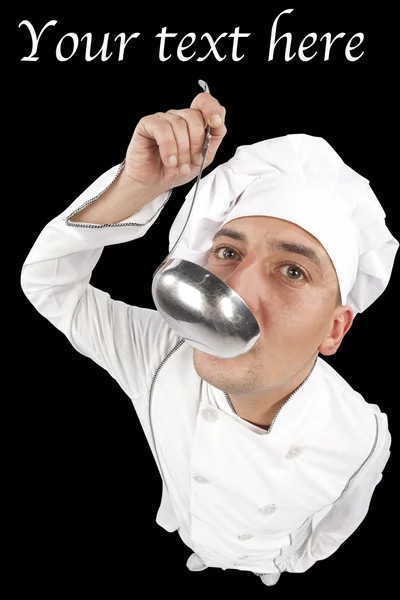 Young chef tasting soup from a ladle — Stock Photo, Image