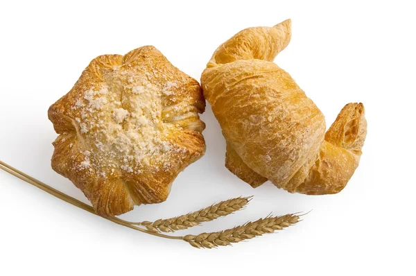 Croissant and bread roll with stems of wheat — Stock Photo, Image