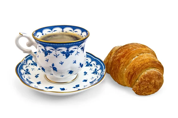 Café en una taza con un patrón azul y cruasán — Foto de Stock