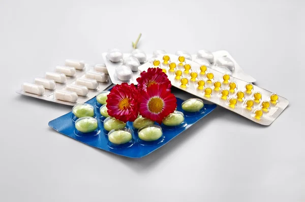 Tablets and capsules with daisies — Stock Photo, Image