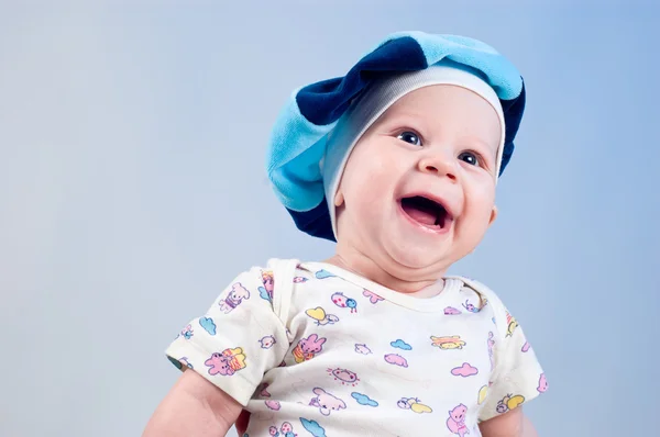 Leuke babyjongen in een baret in een studio op een donker blauwe pagina — Stockfoto