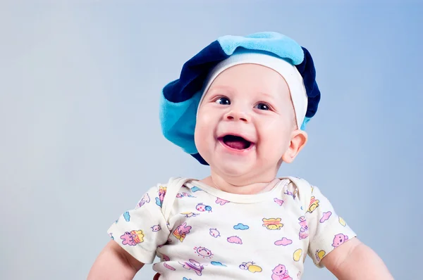 Leuke babyjongen in een baret in een studio op een donker blauwe pagina — Stockfoto