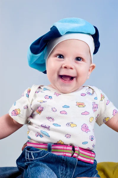 Amusing baby boy in a beret in a studio on a dark blue backgroun — Stock Photo, Image