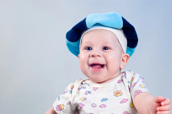 Amusing baby boy in a beret in a studio on a dark blue backgroun — Stock Photo, Image