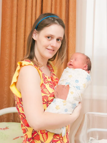 Mulher detém recém-nascido em uma câmara de hospital — Fotografia de Stock