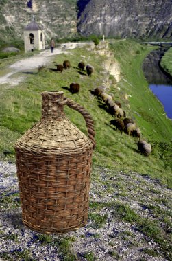 Pot of wine in front of moldavian landscape clipart