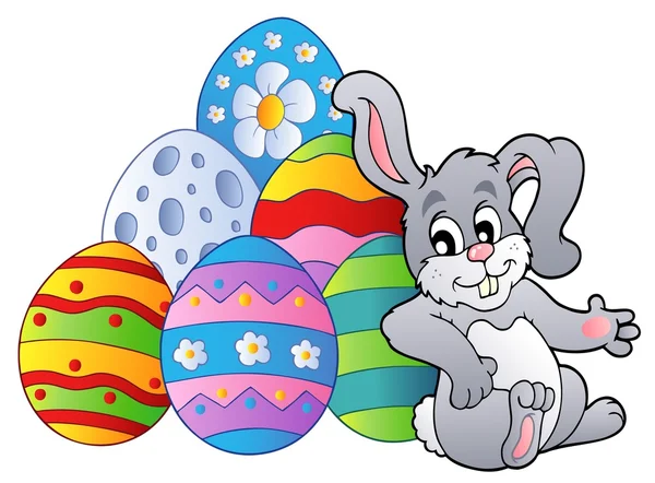 Bunny descansando junto a los huevos de Pascua — Vector de stock