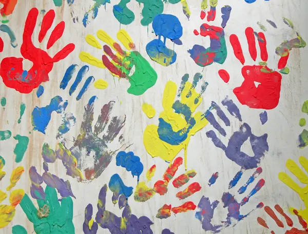 Szivárvány színű handprint konkrét fehér falon, barátság. — Stock Fotó
