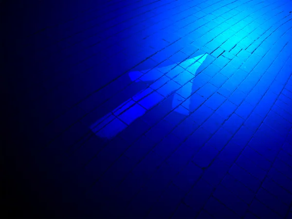 Abstraktní modré osvětlení, bílé směrové značky přemalovány cihla. — Stock fotografie