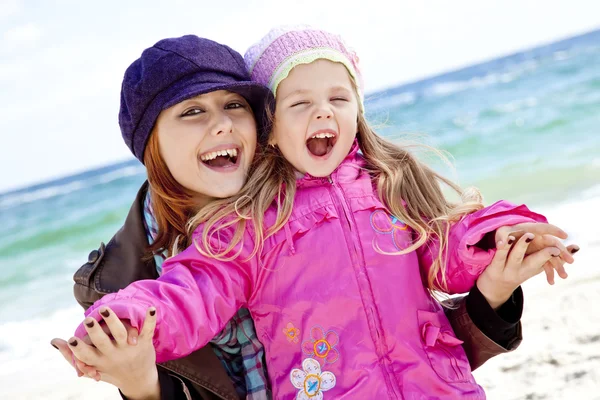 Dos hermanas de 4 y 21 años en la playa en el soleado día de otoño . — Foto de Stock